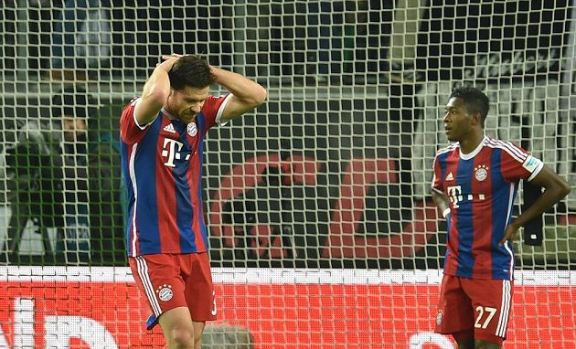 Zklamaný záložník Bayernu Mnichov Xabi Alonso (vlevo) a obránce David Alaba po porážce ve Wolfsburgu.