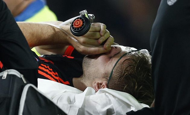 Luke Shaw z Manchesteru United opouští hřiště v Eindhovenu s kyslíkovou maskou.