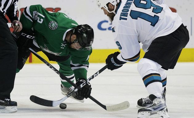 Centr San Jose Sharks Joe Thornton (19) a jeho souboj o puk s centrem Dallasu Stars Radkem Faksou (12) v utkání NHL.
