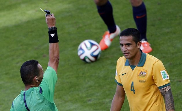 Alžírský sudí Džamel Haimúdi dává žlutou kartu Australanu Timu Cahillovi (4) za zákrok, po němž Nizozemec Bruno Martins Indi předčasně musel opustit hrací plochu.