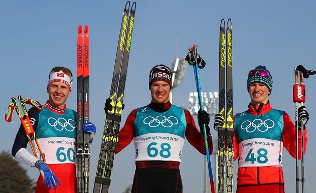 Švýcar Dario Cologna vyhrál jako první běžec na lyžích v olympijské historii potřetí za sebou závod na 15 kilometrů. Stříbro získal Nor Simen Hegstad Krüger (vlevo), jenž vybojoval druhou medaili po triumfu v nedělním skiatlonu. Třetí byl překvapivě Denis Spicov z Ruska.