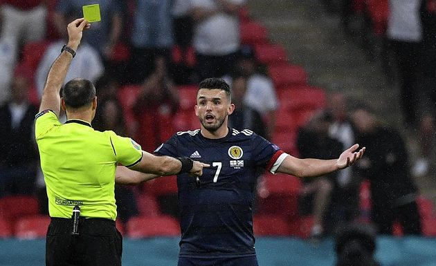 Rozhodčí Antonio Mateu Lahoz ukazuje skotskému reprezentantovi Johnu McGinnovi žlutou kartu v duelu s Anglií na EURO.