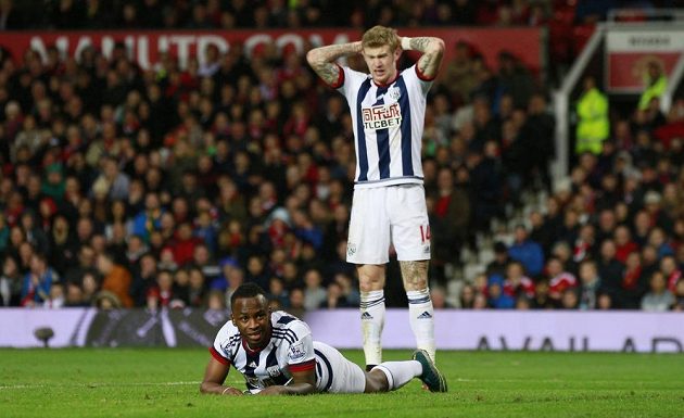 Saido Berahino (ležící) z WBA a James McClean v utkání s Manchesterm United.
