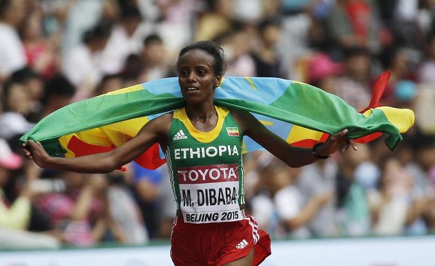 Etiopská vytrvalkyně Mare Dibabaová slaví s vlajkou zlatou medaili z maratónu na mistrovství světa v atletice v Pekingu.