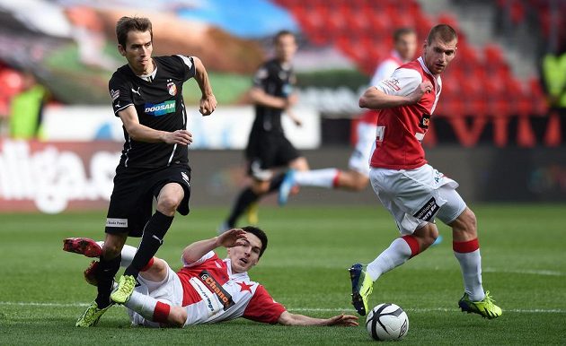 Plzeňský záložník Tomáš Hořava (vlevo) a fotbalisté Slavie Robert Hrubý (na zemi) a Martin Juhar.