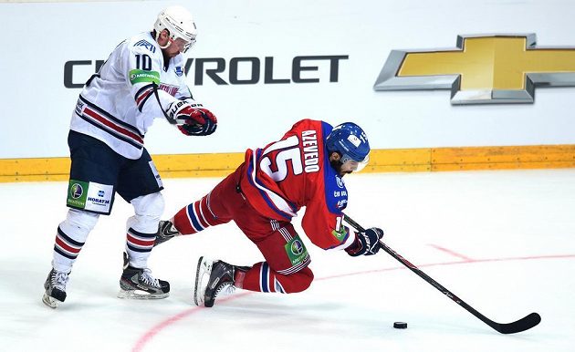 Sergej Mozjakin z Magnitogorsku (vlevo) a Justin Azevedo ze Lva Praha bojují o puk během utkání finále play off KHL.