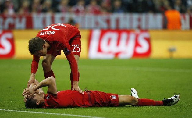 Robert Lewandowski leží na trávníku po neproměněné šanci v odvetě semifinále Ligy mistrů proti Atlétiku Madrid. Nad ním stojí Thomas Müller.