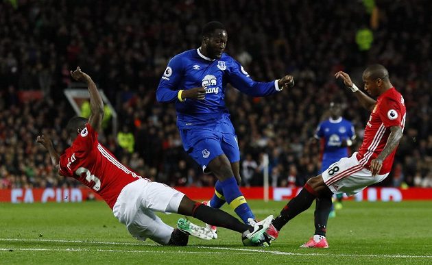 Útočník Evertonu Romelu Lukaku v akci během utkání Premier League na hřišti Manchesteru United. Snaží se ho zastavit dva soupeři.