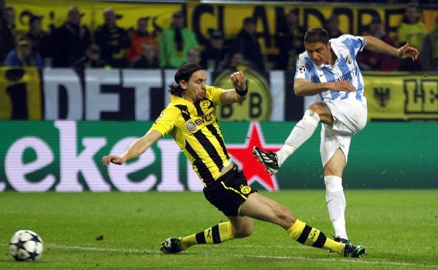 Joaquín z Málagy (vpravo) střílí i přes skluz Nevena Subotiče z Borussie Dortmund gól.