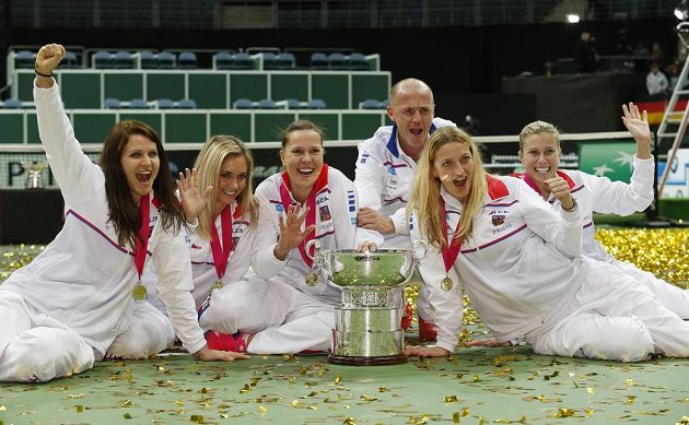 Úspěšné tenistky zleva Lucie Šafářová, Klára Koukalová, Lucie Hradecká, kapitán Petr Pála, Petra Kvitová a Andrea Hlaváčková pózují s pohárem pro vítězky Fed Cupu.