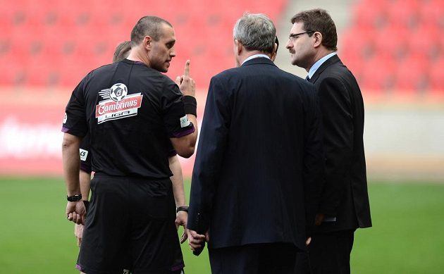 Rozhodčí Miroslav Zelinka (vlevo) reší s hlavním pořadatelem a delegátem pokřiky fanoušků Slavie během utkání s Jabloncem.