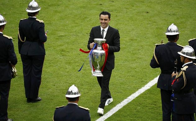 Španělský fotbalista Xavi přináší trofej pro nové mistry Evropy před začátkem finále.