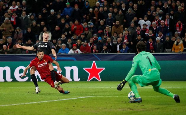 Kanonýr Salcburku Erling Braut Haaland pálí přes bránícího zadáka Liverpoolu Dejana Lovrena. Brankář anglického klubu Alisson Becker ale míč za svá záda nepustil.