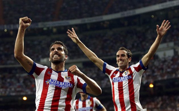 Raúl Garcia (vlevo) a jeho spoluhráč Diego Godín slaví vyrovnávací gól Atlétika na Santiago Bernabéu.