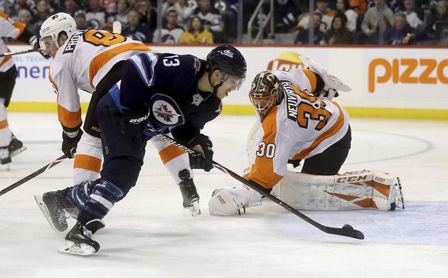 Hokejista Winnipegu Jets Brandon Tanev (13) překonává brankáře Philadelphie Michala Neuvirtha (30) v utkání NHL.
