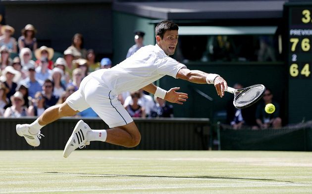 Novak Djokovič ze Srbska při akrobatickém zákroku v semifinále Wimbledonu s Francouzem Richardem Gasquetem.