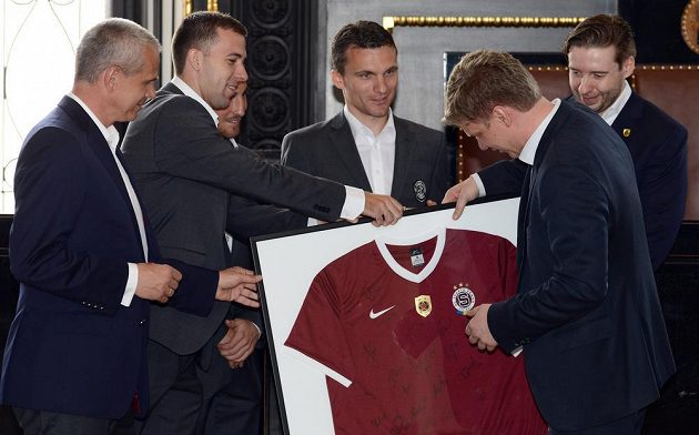 Pražský primátor Tomáš Hudeček (vpravo) dostává od zástupců Sparty podepsaný dres.