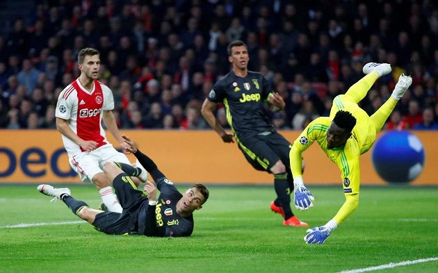 Míč míří do brány Ajaxu. Ležící Cristiano Ronaldo z Juventusu se může začít radovat.