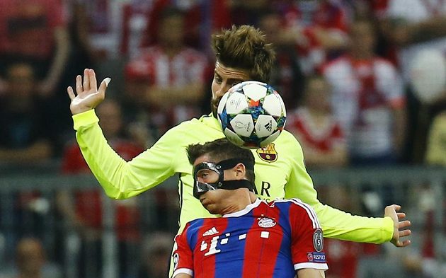 Robert Lewandowski (dole) z Bayernu v souboji se zadákem Gerardem Piquém z Barcelony.