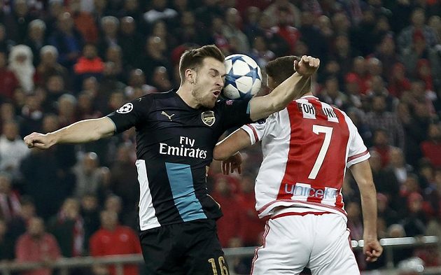 Aaron Ramsey (vlevo) z Arsenalu v hlavičkovém souboji s Kostasem Fortunisem z Olympiakosu Pireus.