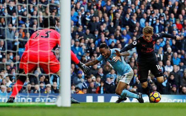 Hráč Manchesteru City Raheem Sterling padá v pokutovém území po zákroku Nacho Monreala a sudí nařídil penaltu. Vše mohl sledovat gólman Kanonýrů Petr Čech.
