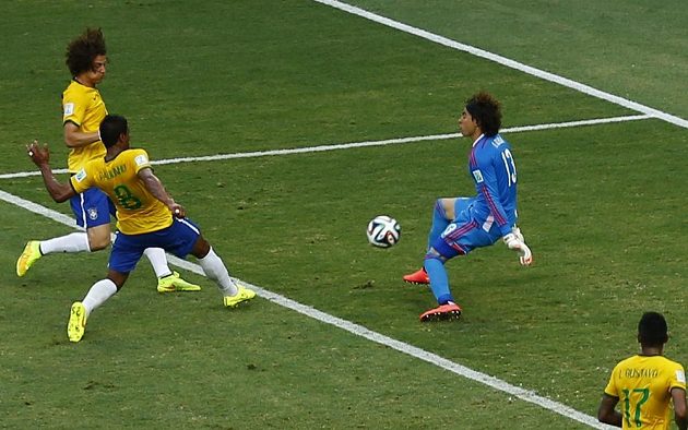 Guillermo Ochoa (vpravo) likviduje šance Brazilců Davida Luize (vlevo nahoře) a Paulinha.