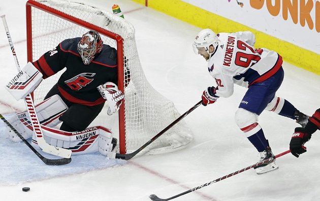 Český gólman Caroliny Hurricanes Petr Mrazek likviduje šanci ruského útočníka Kuzněcova v utkání 1. kola play off NHL.