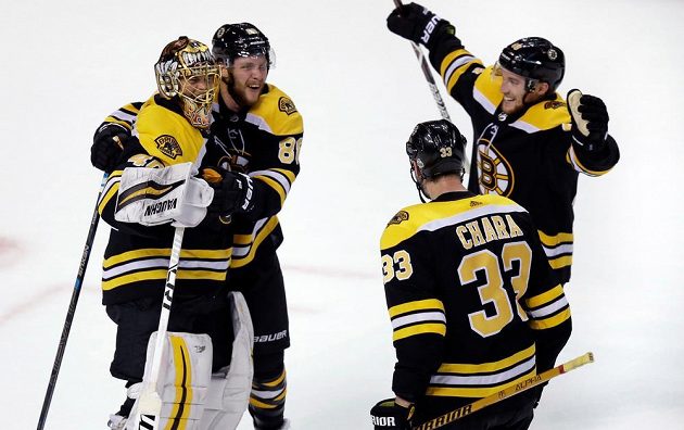 Bostonský gólman Tuukka Rask přijímá gratulace od spoluhráčů, zprava Matt Grzelcyk, Zdeno Chara a David Pastrňák.