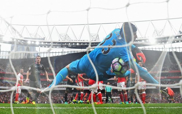 Míč se odráží od těla Petra Čecha do brány Arsenalu. Dušan Tadič ze Southamptonu těsně před tím trefil z přímého kopu břevno.