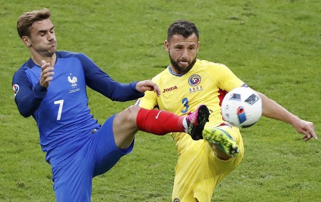 Razvan Rat z Rumunska (vpravo) bojuje o míč s Antoinem Griezmannem z Francie.