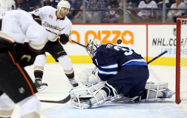 Brankář Winnipegu Ondřej Pavelec likviduje šanci útočníka Anaheimu Daniela Winnika (druhý zprava).