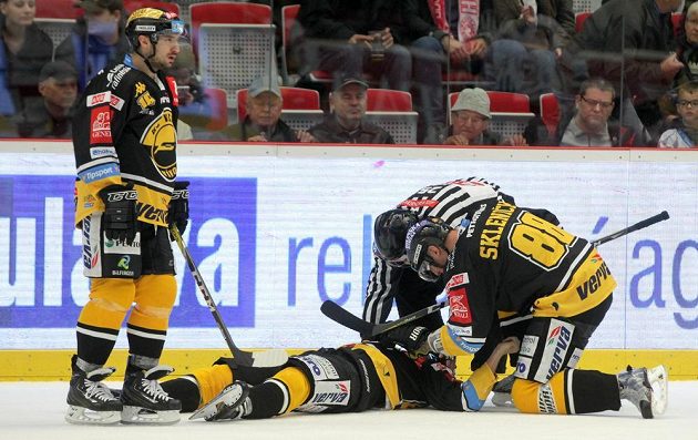 František Lukeš z Litvínova (vlevo) stojí nad svým zraněným spoluhráčem Ondřejem Jurčíkem. Vpravo Zbyněk Sklenička.