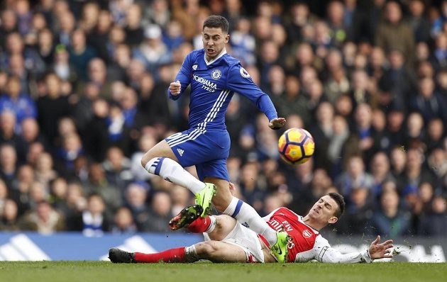 Hvězdu Chelsea Edena Hazarda se skluzem snaží zastavit Laurent Koscielny z Arsenalu.