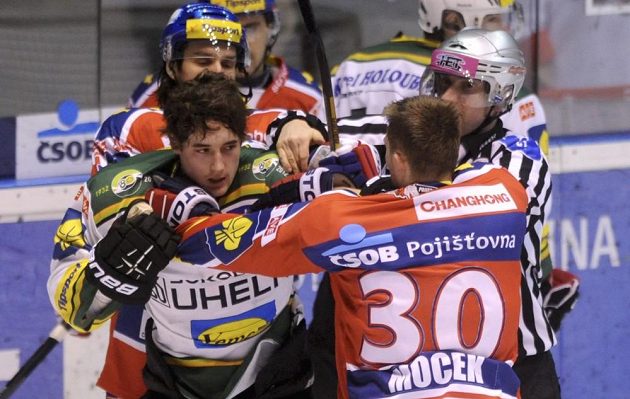Pardubický obránce Petr Mocek (v červeném dresu s číslem 30) v potyčce s karlovarským útočníkem Michalem Vachovcem.