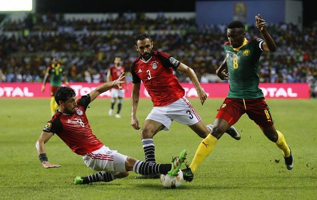 Egypťané Tarek Hamed a Ahmed Elmohamady v obranném zákroku proti Benjaminu Moukandjoovi z Kamerunu.