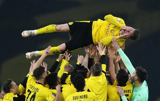 Lukasz Piszczek nad hlavami spoluhráčů po dortmundském triumfu v Německém poháru.