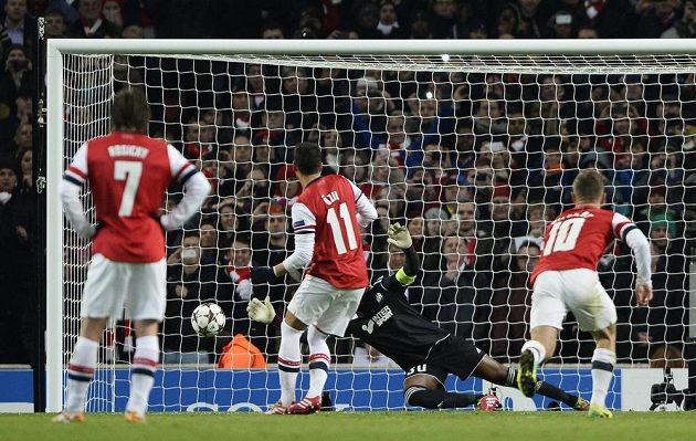 Brankář Olympique Marseille Steve Mandanda chytá střelu z pokutového kopu Mesuta Özila z Arsenalu.