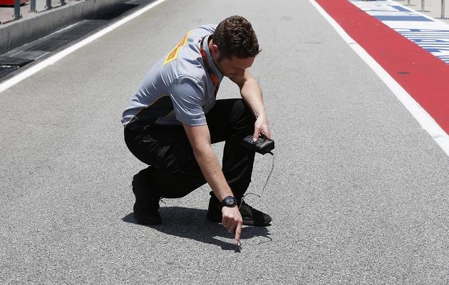 Technik Pirelli měří teplotu asfaltu na okruhu v Sepangu. Tropické vedro v Malajsii umí jezdce pořádně potrápit.