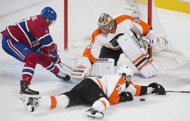 Obránce Philadelphie Radko Gudas (3) blokuje přihrávku v zápase NHL proti Montrealu. Z brány vše pozoruje Michal Neuvirth (30).