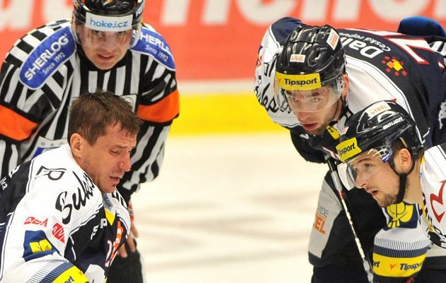 Hokejisté Vítkovic (zprava) Ondrej Šedivý a Richard Stehlík u zraněného spoluhráče Petera Húževky (vlevo).