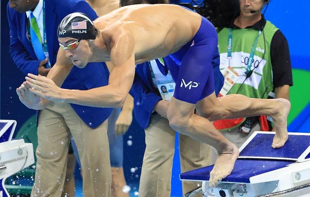 Michael Phelps se vrhá do bazénu na druhém úseku americké štafety 4x100 m.