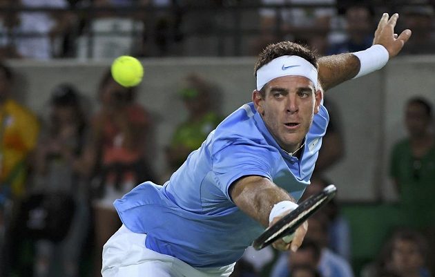 Juan Martín del Potro se snaží dosáhnout na míček v zápase s Novakem Djokovičem.