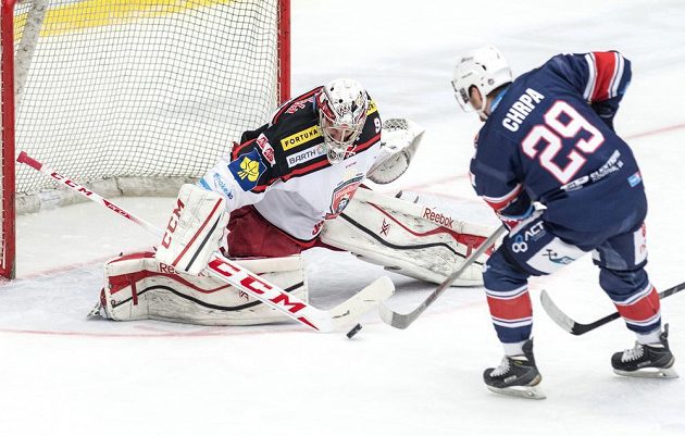 Jakub Chrpa (vpravo) z Chomutova překonává královéhradeckého brankáře Ondřeje Kacetla v zápase 50. kola hokejové Tipsport extraligy.