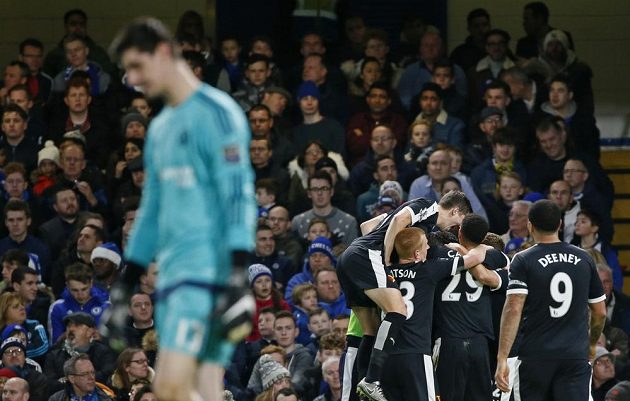 Hráči Watfordu slaví branku Odiona Ighala, v popředí zklamaný gólman Chelsea Thibaut Courtois.