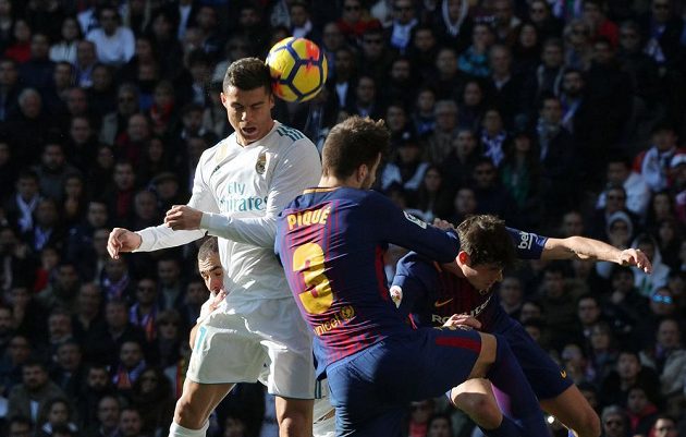 Cristiano Ronaldo z Realu v hlavičkovém souboji s Gerardem Piquém z Barcelony.
