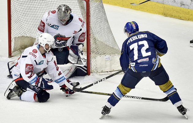 Brett Flemming z Chomutova, brankář Chomutova Justin Peters a Linus Svedlund z Kladna v akci během utkání baráže o hokejovou extraligu.