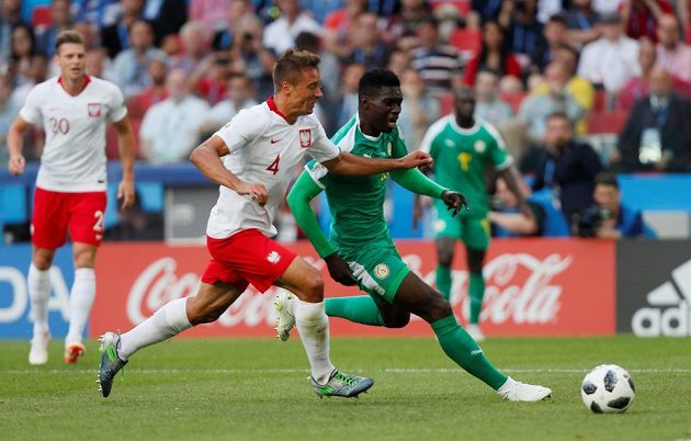 Senegalec Ismaila Sarr v souboji s Polákem Thiagem Cionekem během utkání MS.