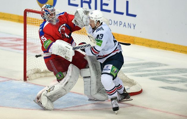 Český útočník Magnitogorsku Jan Kovář (vpravo) fauluje brankáře Lva Praha Petriho Vehanena během utkání finále play off KHL.