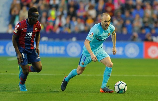 Barcelonský Andres Iniesta v akci během utkání s Levante. Jeho hráč Emmanuel Boateng pohledem kontroluje barcelonskou legendu.