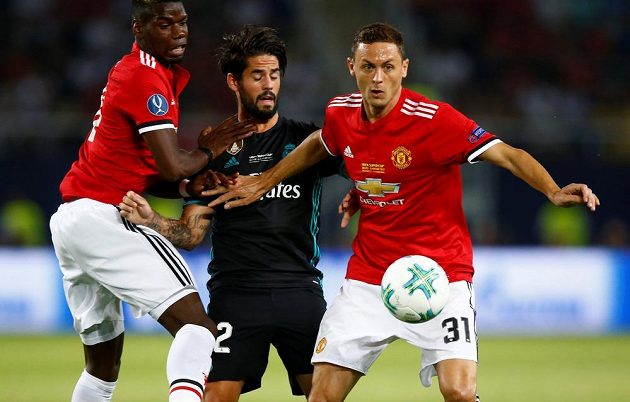 Isco z Realu Madrid v obležení hráčů Manchesteru Nemanji Matiče (vpravo) a Paula Pogby.